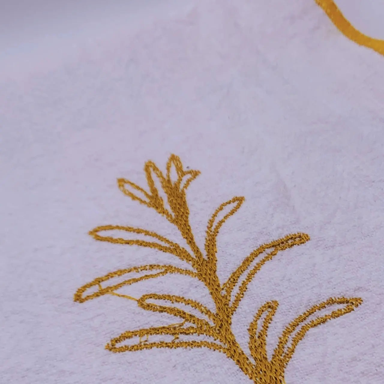 Serviette en lin lavé couleur blanc finition dorée_brodée d'une plante aromatique