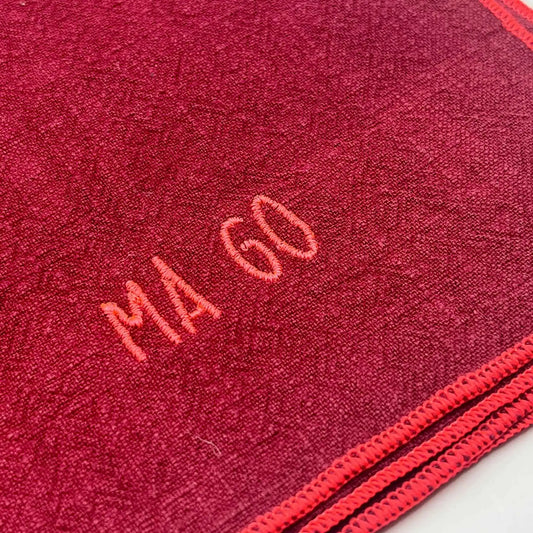 Serviette en lin lavé couleur framboise, finition rose néon, avec un nom brodé. Vue du détail de la broderie du produit