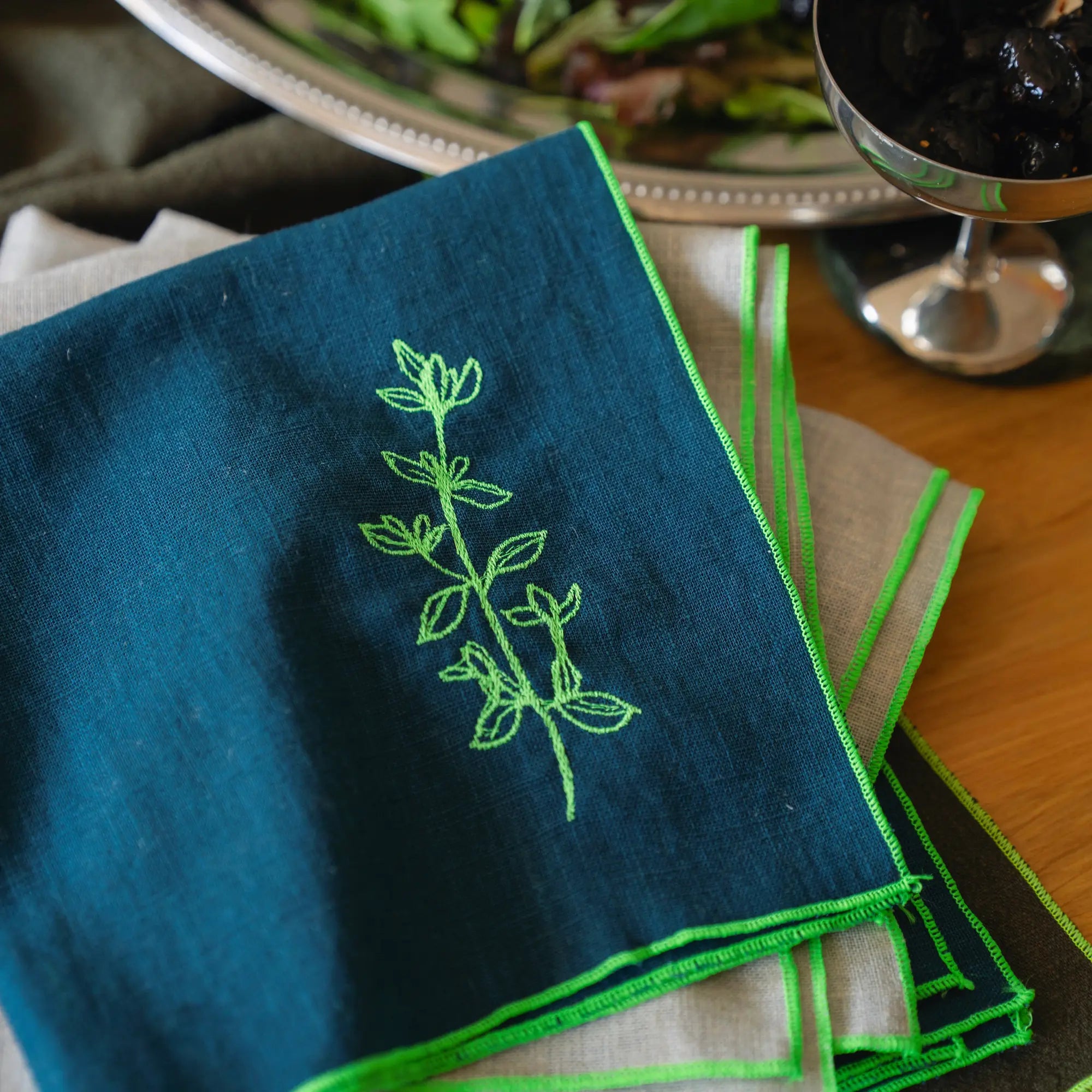 Serviettes en lin grises et bleues brodées de plantes aromatique comme le thym, le romarin, la sariette, la lavande.