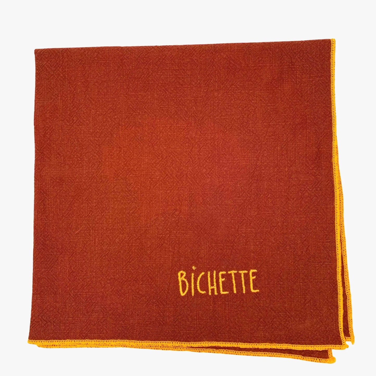 Serviette en lin lavé couleur piment, finition orange néon, brodé d'un prénom. vue du produit