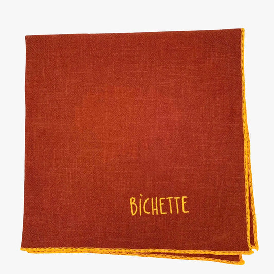 Serviette en lin lavé couleur piment, finition orange néon, brodé d'un prénom. vue du produit