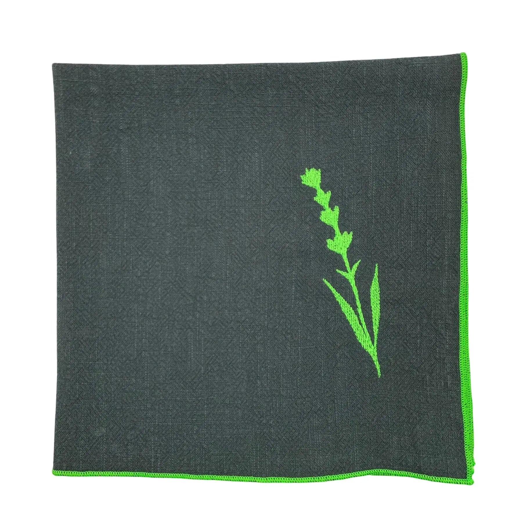 Serviette de table en lin lavé de couleur vert forêt, avec des finitions en vert néon. Elle est brodée d'un motif de lavande, une plante aromatique. Vue du produit.