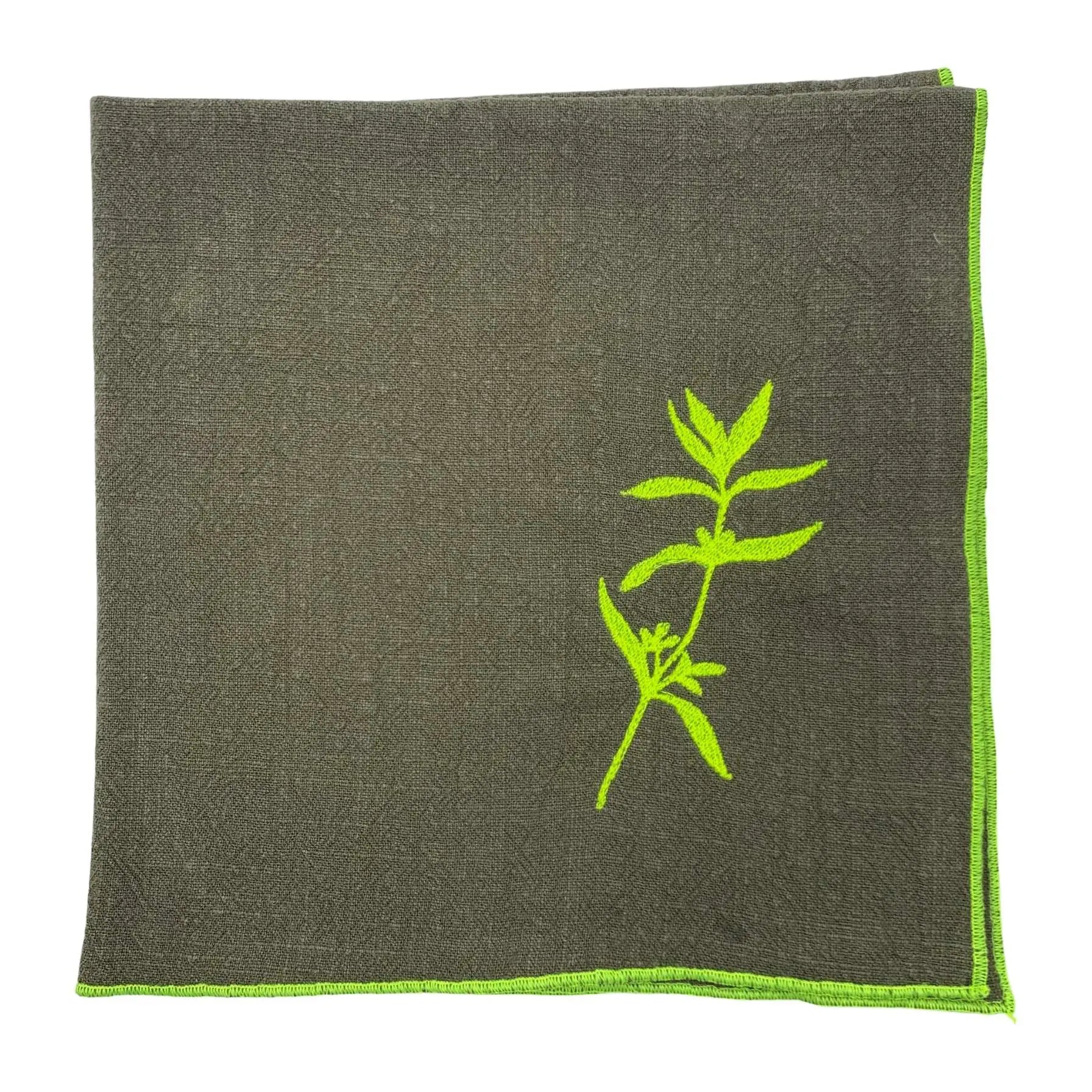 Serviette de table en lin lavé de couleur vert safari, ornée de finitions en jaune néon. Elle présente un motif brodé de sarriette, une plante aromatique. Vue du produit.