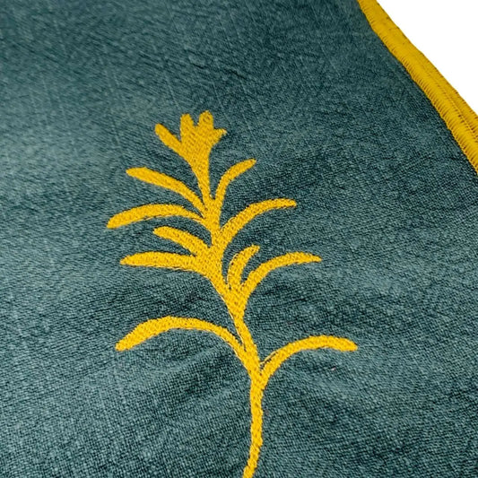 Serviette en lin lavé couleur vert forêt, finition dorée_brodée d'une plante aromatique